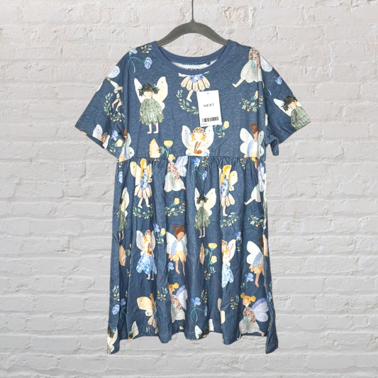 Blue dress with fairy print design, new with tags from Next, hanging on a black hanger against a brick wall.