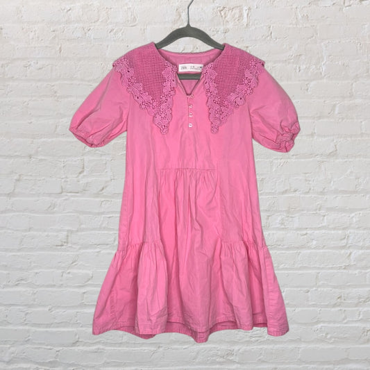 Pink dress by Zara with a crochet collar and buttons down the front, displayed on a hanger.