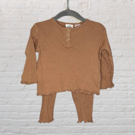Brown ribbed two-piece baby outfit with long sleeves and frilled edges, featuring button accents on the top.