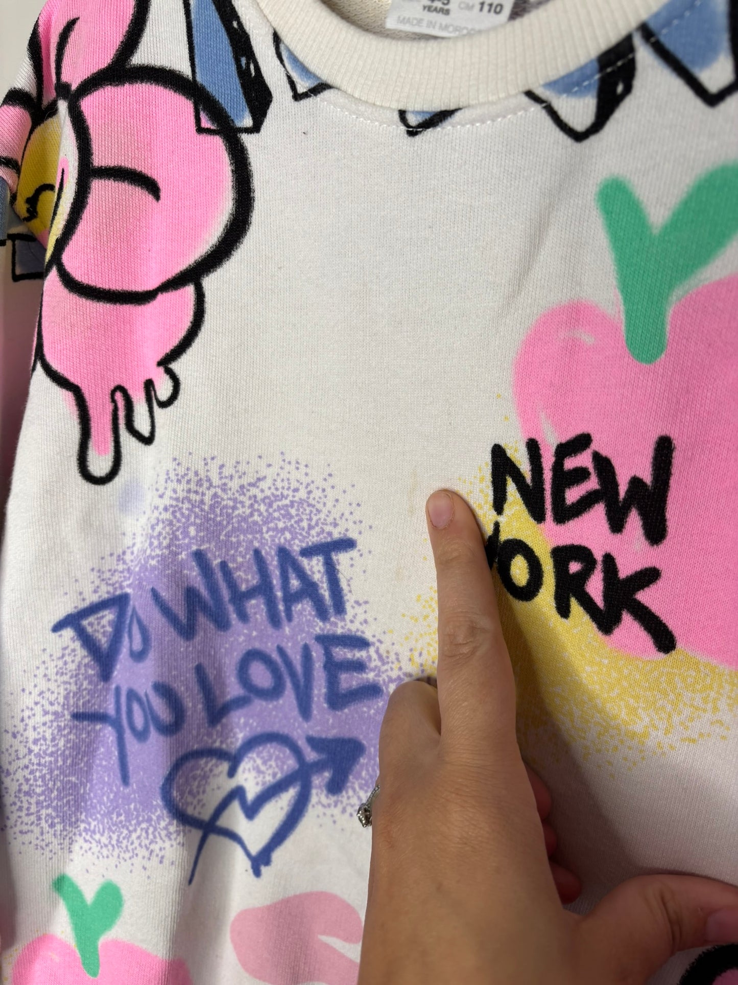 Colourful graffiti art sweatshirt featuring flowers, hearts, and New York themed text.