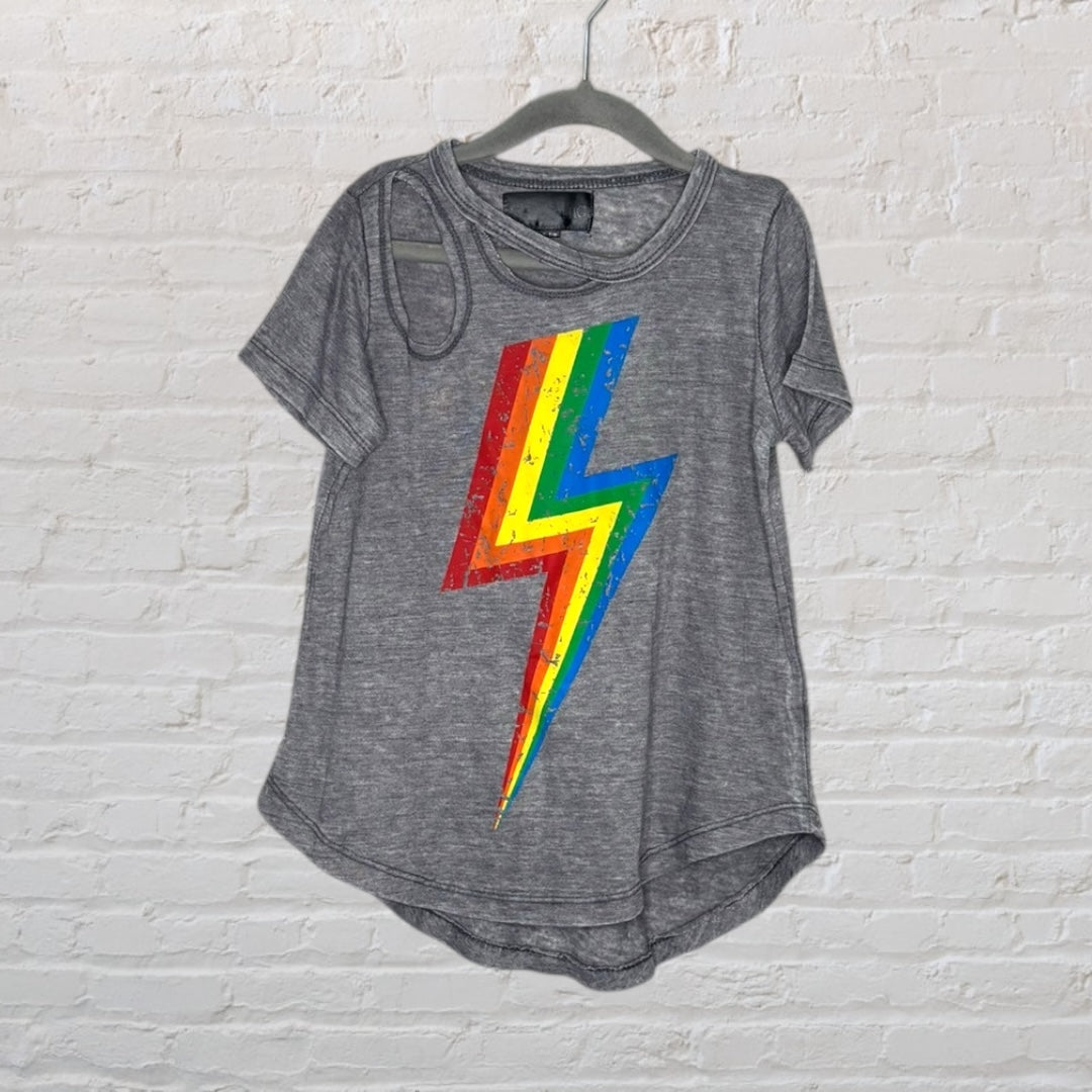 Grey T-shirt with rainbow lightning bolt design and shoulder cutout, hanging on a dark hanger.