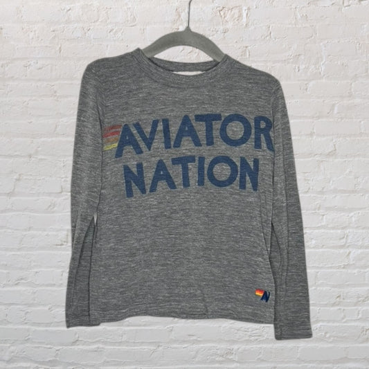 Heather gray long sleeve t-shirt with 'Aviator Nation' in blue letters, featuring rainbow stripes, on a hanger.