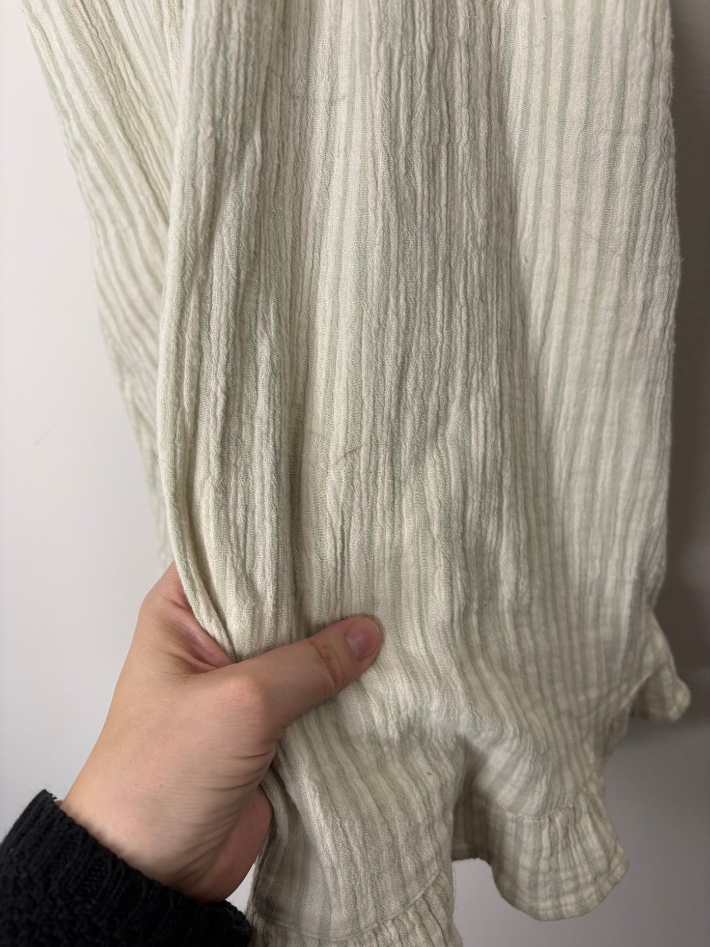 Women's two-piece outfit with cream and beige stripes, featuring a sleeveless button-down top and a matching long skirt with ruffled hem.