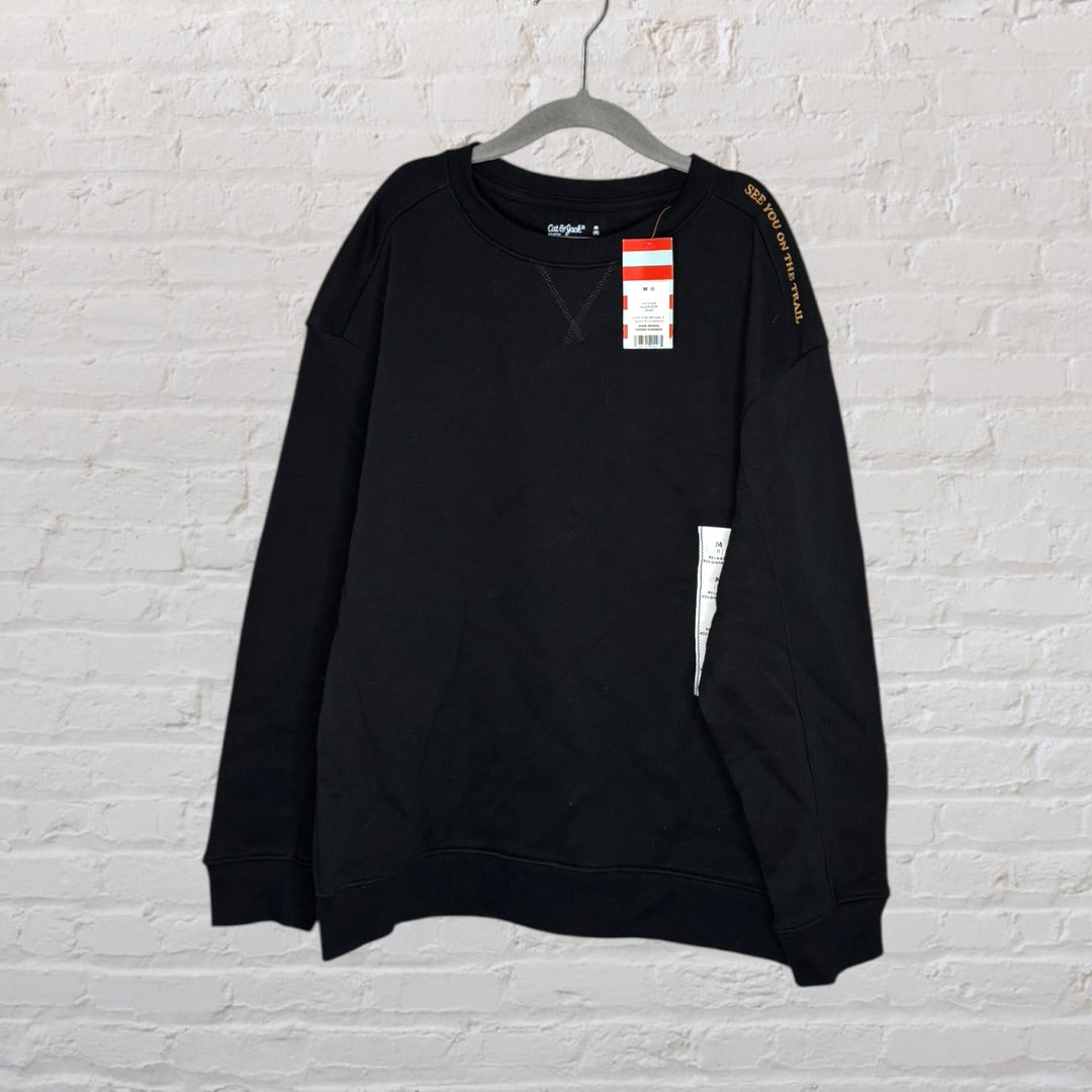 Black sweatshirt with 'Leave No Trace' text and a whimsical graphic of a creature with a backpack, displayed on a hanger.