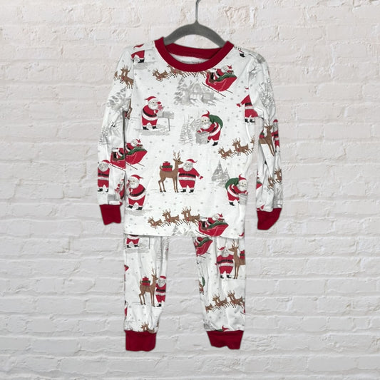 Festive Christmas pajama set with Santa and reindeer print in white and red, hanging on a grey hanger.