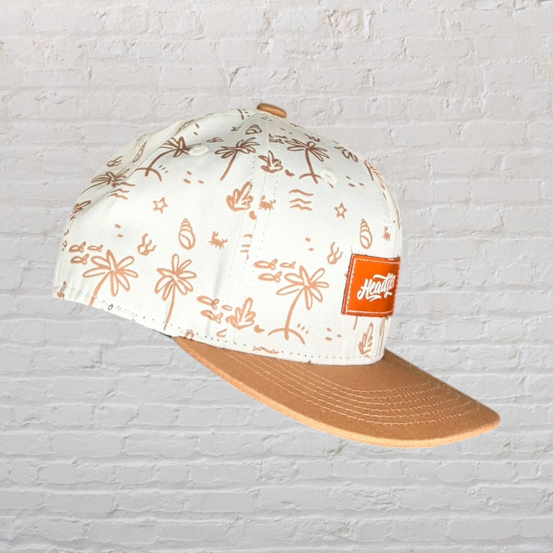 Beige and brown cap with tropical print design and Headster logo patch on front.