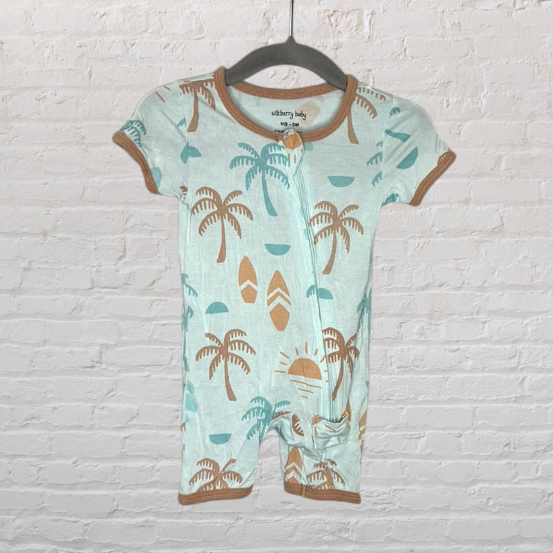 Light blue baby romper with brown tropical print and contrasting trims, hanging on a black hanger.