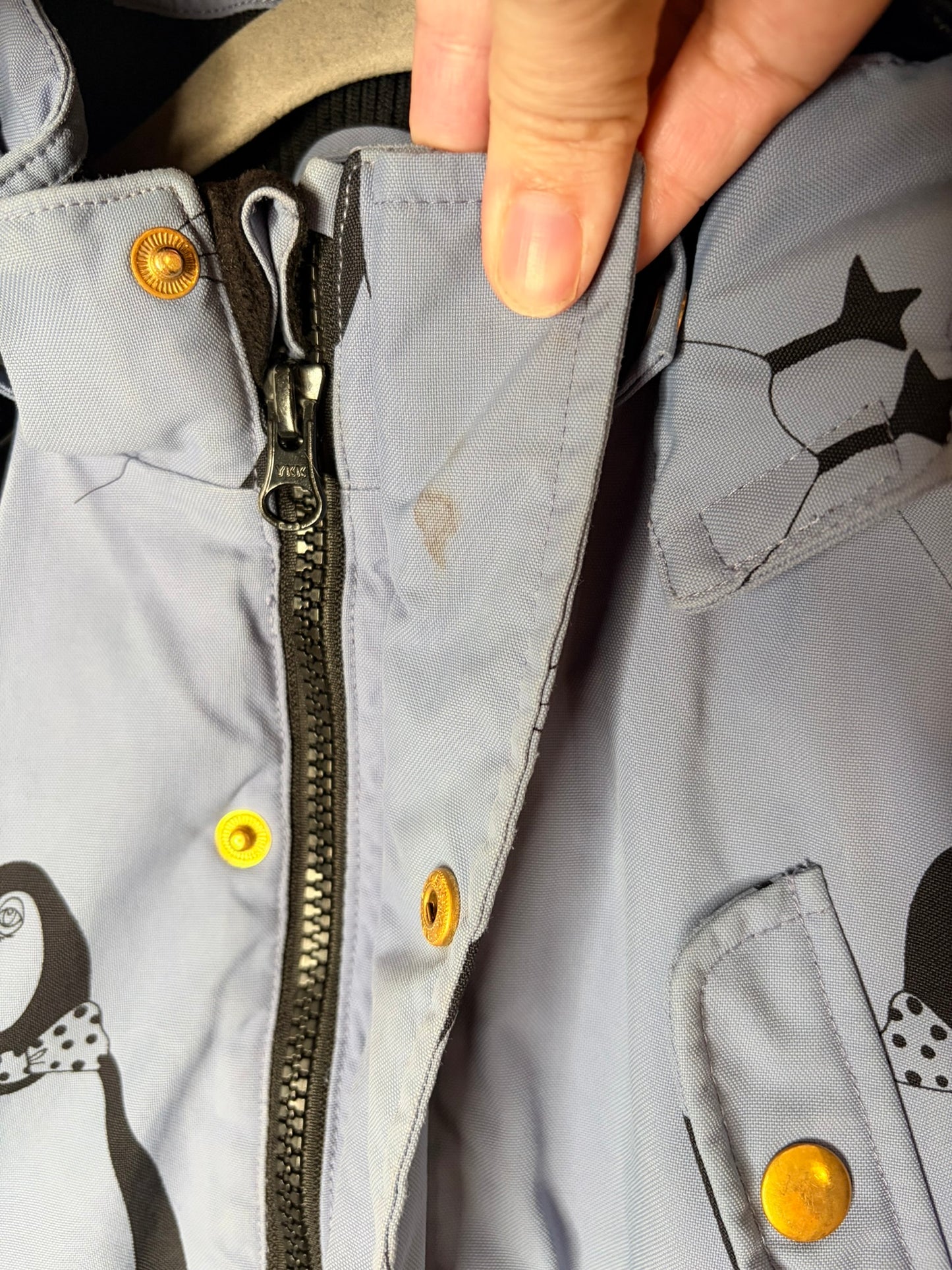 Grey parka with penguin print, featuring a faux fur trimmed hood and reflective patch on the sleeve.