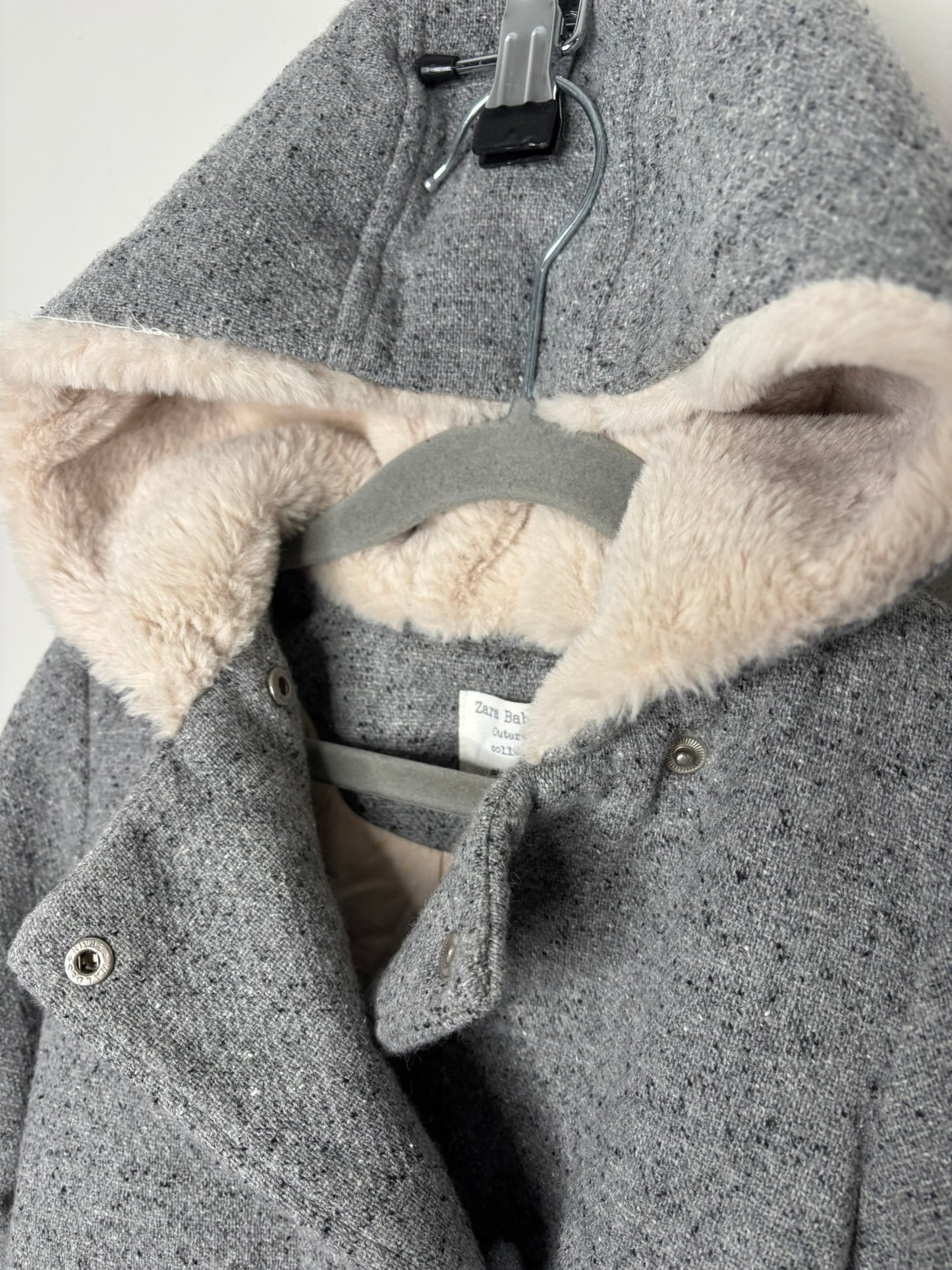 Grey wool blend coat with hood and faux fur lining from Zara Kids, displayed on a hanger.