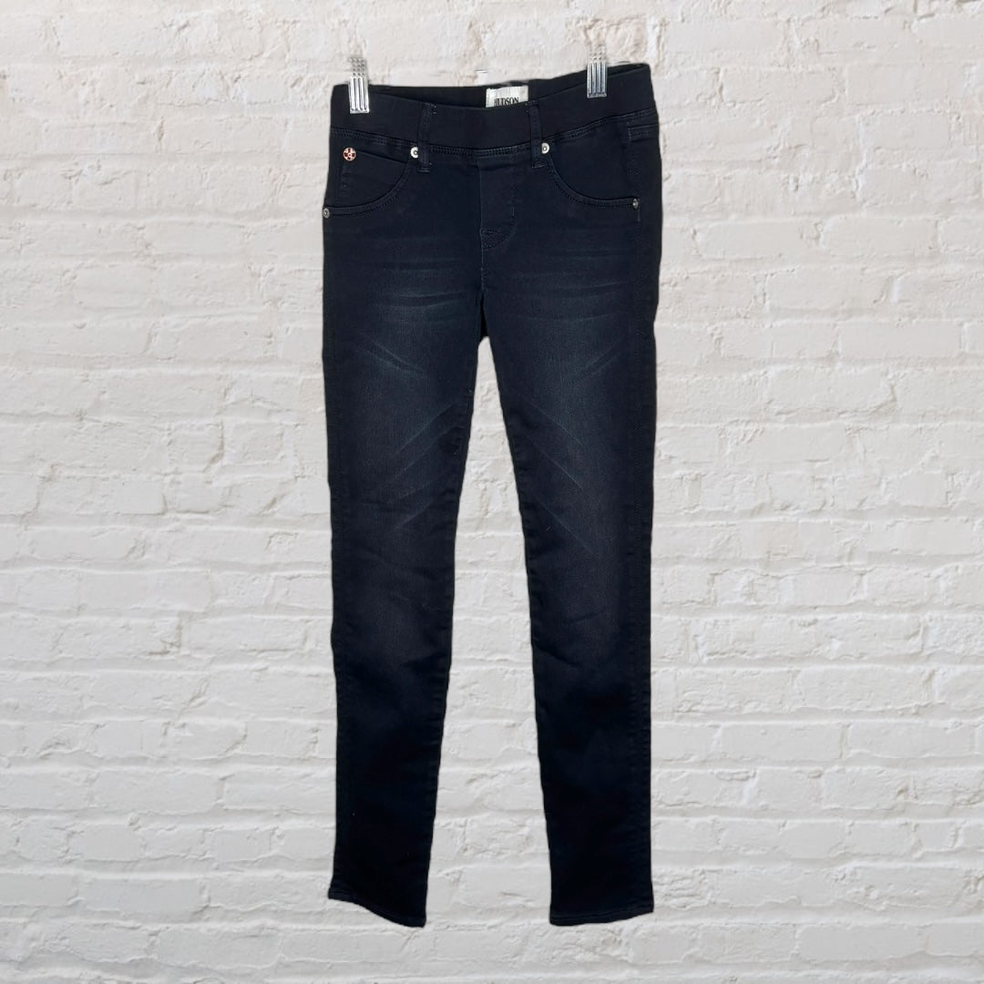 Dark wash skinny fit jeans for women by YMI, displayed on hangers against a brick wall.