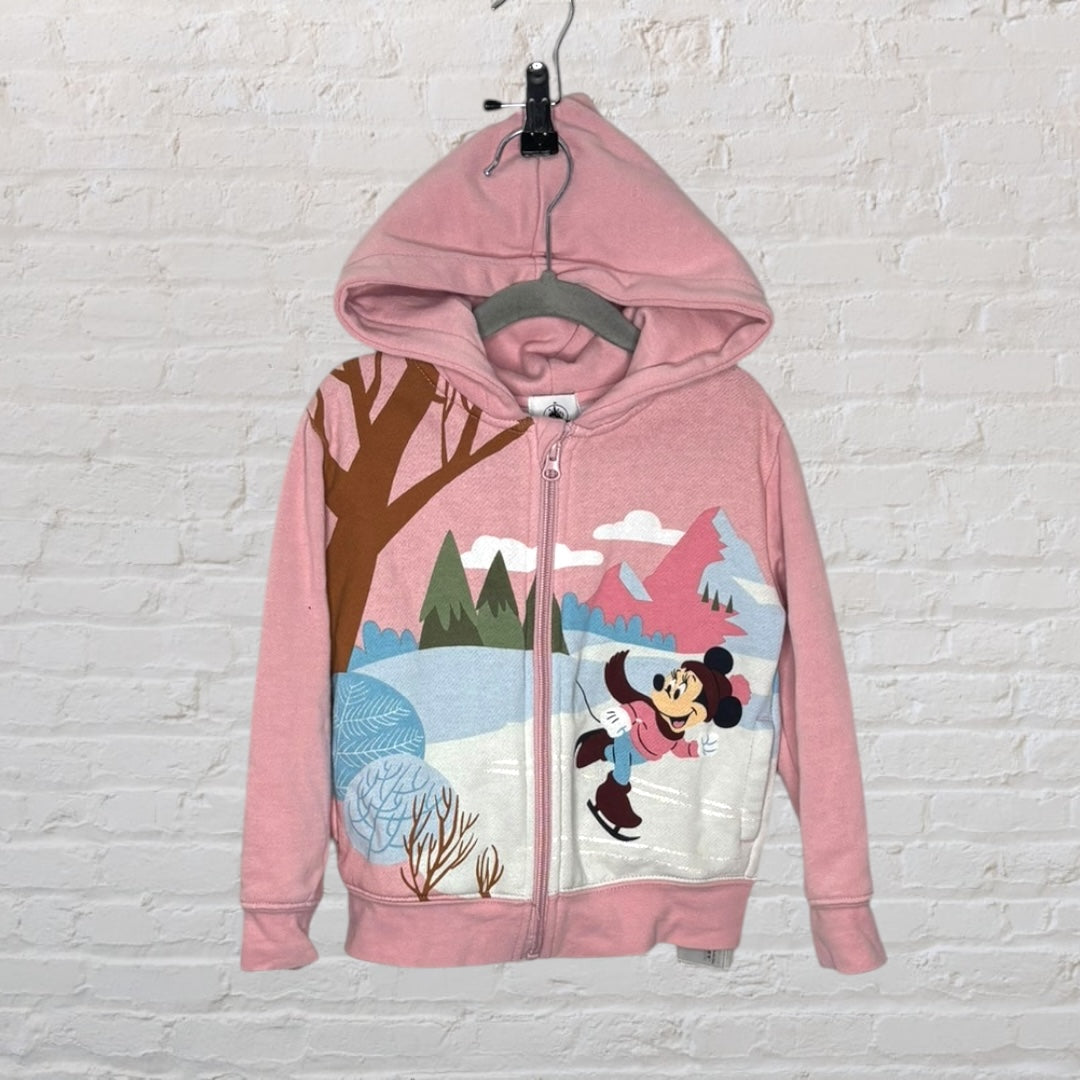 Pink hoodie with Minnie Mouse ice skating graphic against a winter backdrop, featuring a zip front and hood.