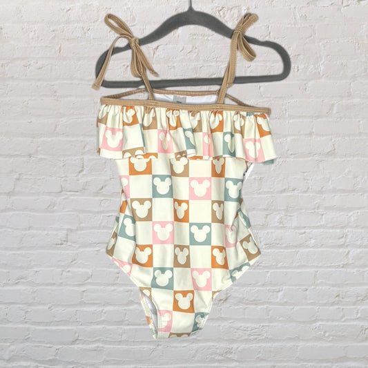 Swimsuit featuring a Mickey Mouse checkerboard pattern with ruffle trim and tie straps in cream and pastel colors.
