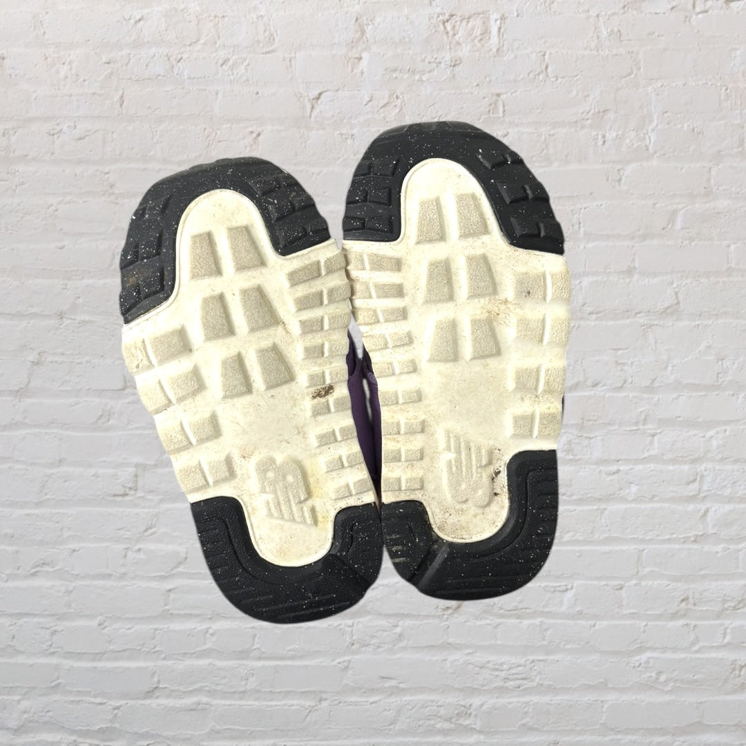 Purple New Balance 574 kids sneakers with aqua logo and Velcro straps.