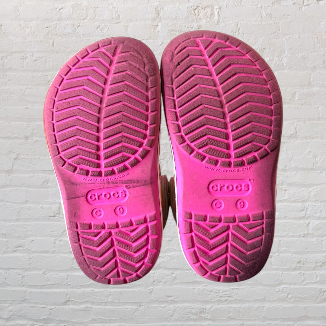 Pink Crocs clogs with Minnie Mouse design and Disney character print on the sole, featuring adjustable heel strap.