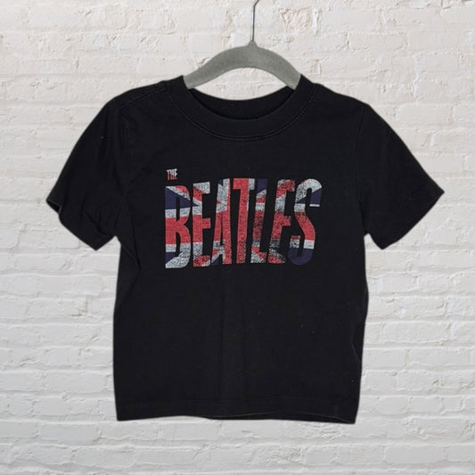 Black T-shirt with The Beatles logo in Union Jack design, short sleeves, hanging on hanger.