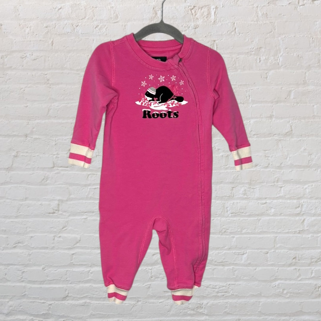 Pink Roots baby onesie with star and beaver graphic, long sleeves, and ribbed cuffs, hanging on a hanger.