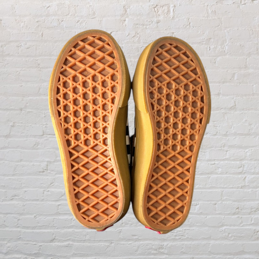 Pair of high-top sneakers with a black and white checkered pattern, brown detailing, and velcro straps.