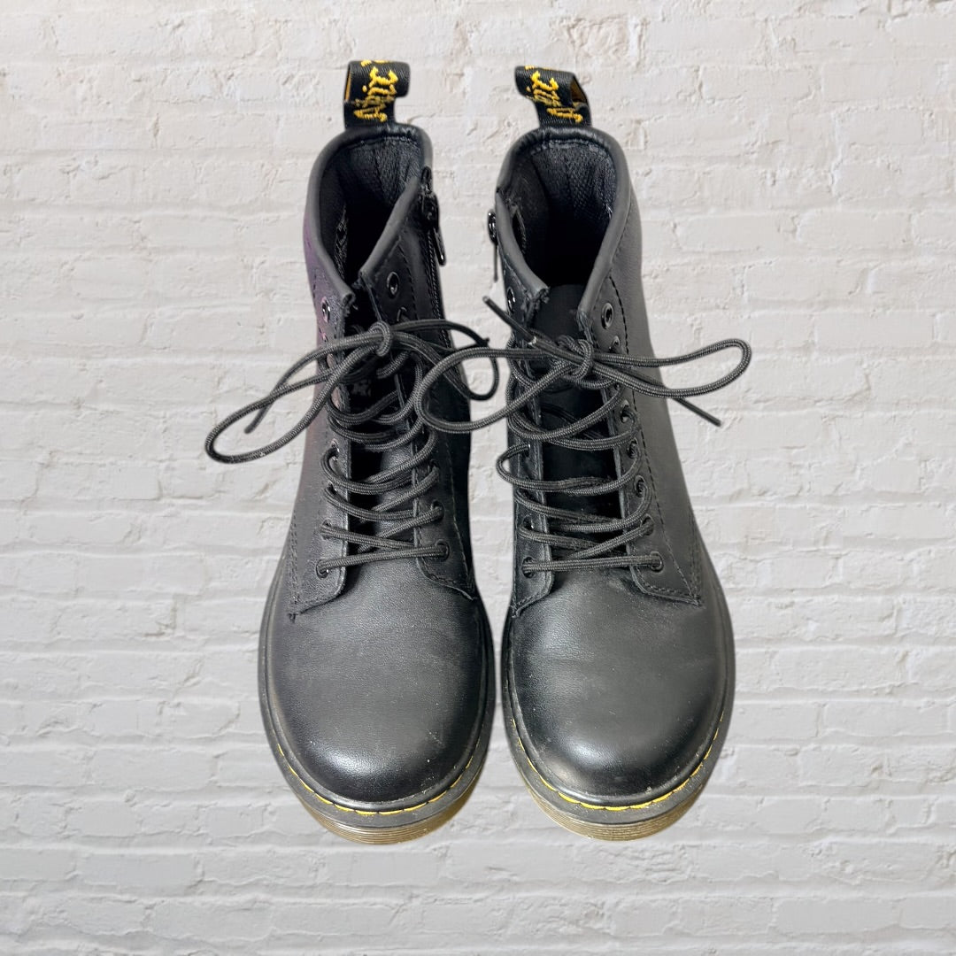 Black Dr. Martens lace-up combat boots with signature yellow stitching and pull tab.