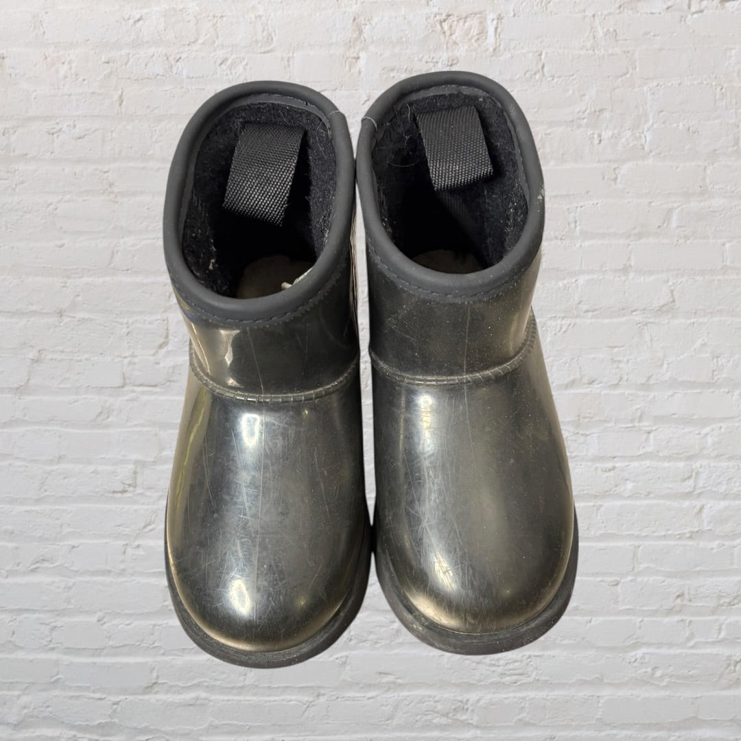 Pair of UGG short rubber boots in black with UGG logo on the side.