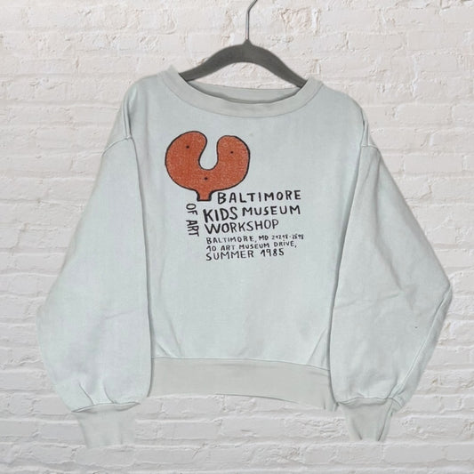Light grey sweatshirt with Baltimore Kids Museum Workshop graphic in orange and black, featuring a summer 1985 event design.