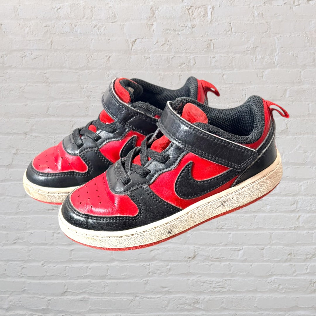 Pair of red and black low-top Nike sneakers with visible wear, Velcro straps, and laces.