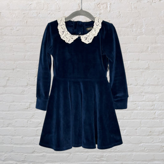 Navy blue velvet dress with long sleeves and a white lace collar, hanging on a grey hanger.