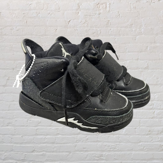 Black high-top sneakers for kids with laces and strap, featuring a textured design on the sides.