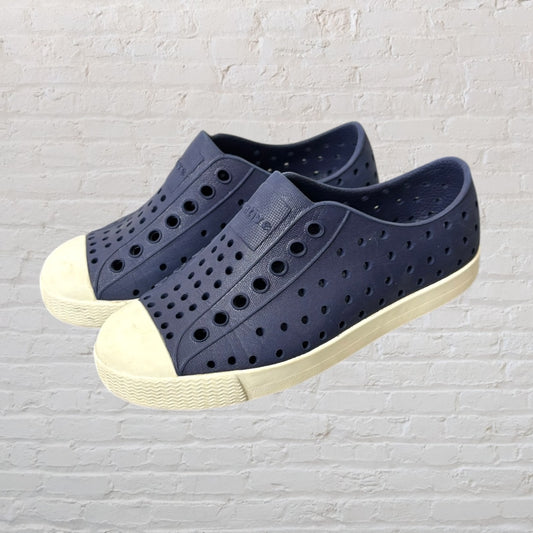 Navy perforated slip-on shoes with white soles, designed for casual wear.