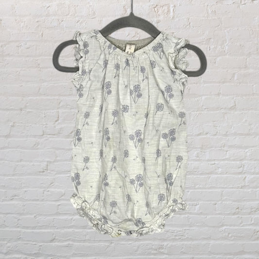 Light grey baby romper with purple floral print and ruffled sleeves, hanging on a black hanger.