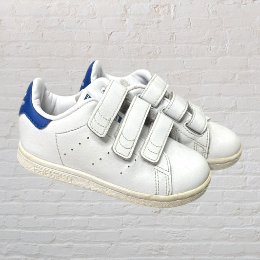 Unisex white leather sneakers with three velcro straps and blue heel detail.