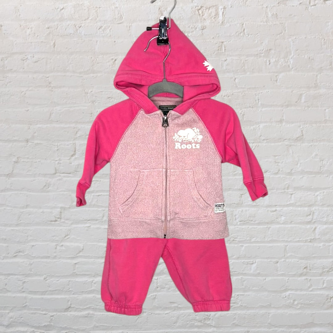 Pink Roots zip-up hoodie set with logo, featuring a hood and front pockets, displayed on a hanger.