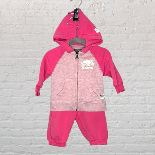 Pink Roots zip-up hoodie set with logo, featuring a hood and front pockets, displayed on a hanger.