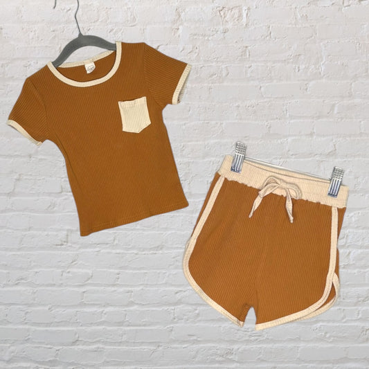 Brown and cream ribbed short-sleeve T-shirt with pocket and matching shorts set displayed against a brick wall.