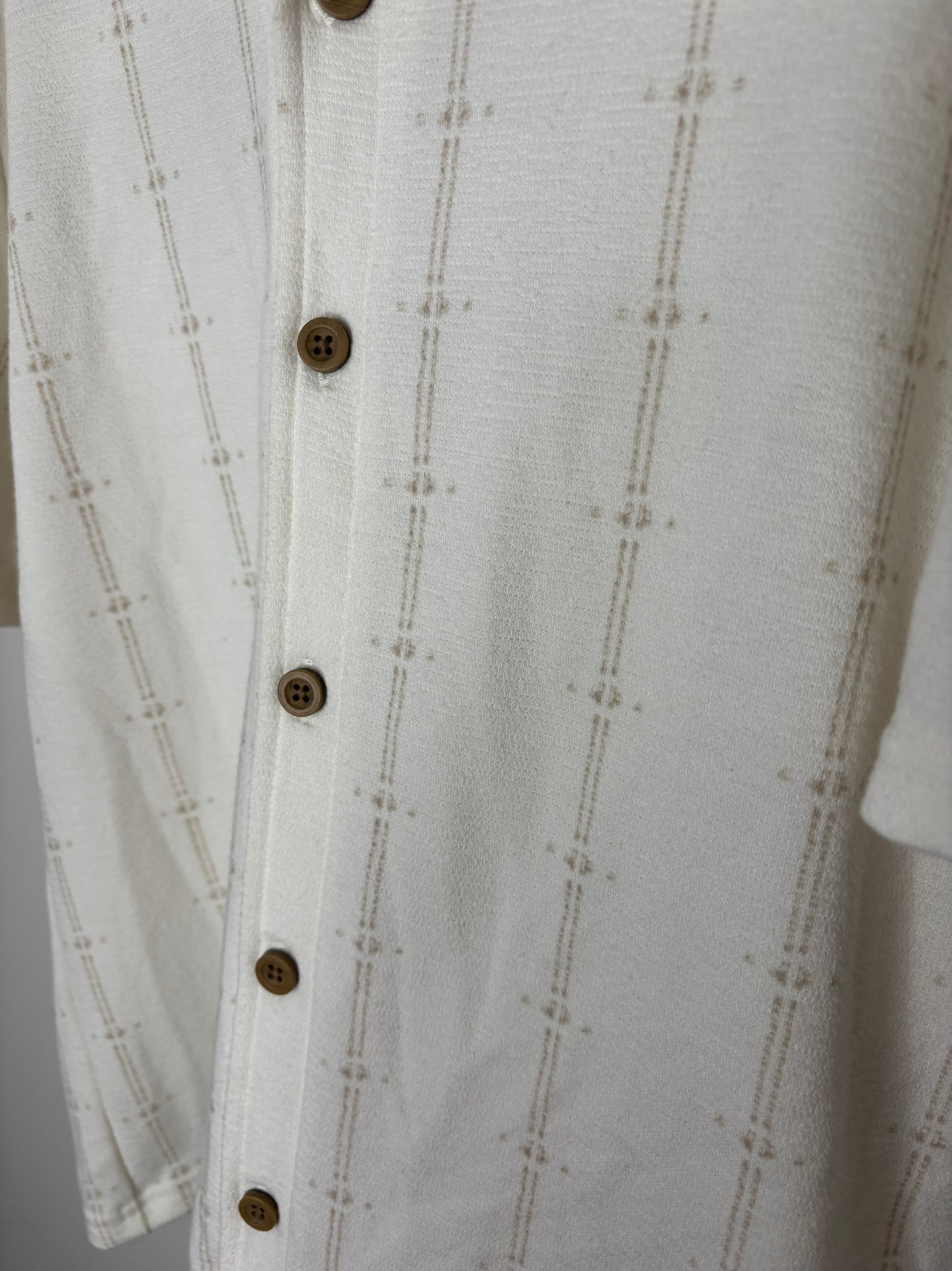 Off-white short sleeve button-up shirt with textured pattern, displayed on a hanger.