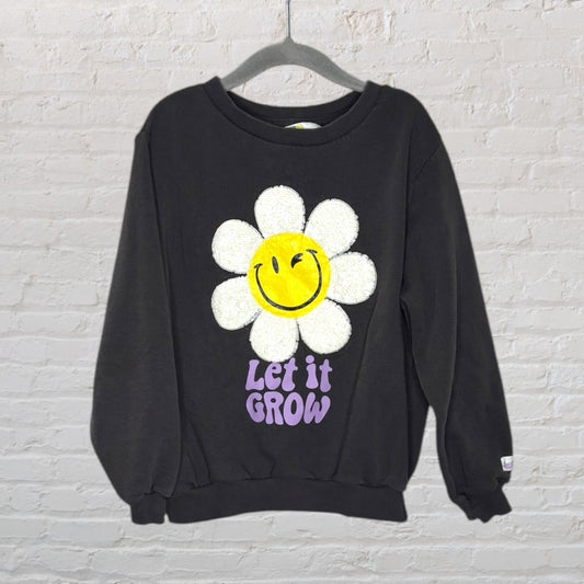 Black sweatshirt with a smiling flower graphic and the phrase 'Let It Grow' in purple text.