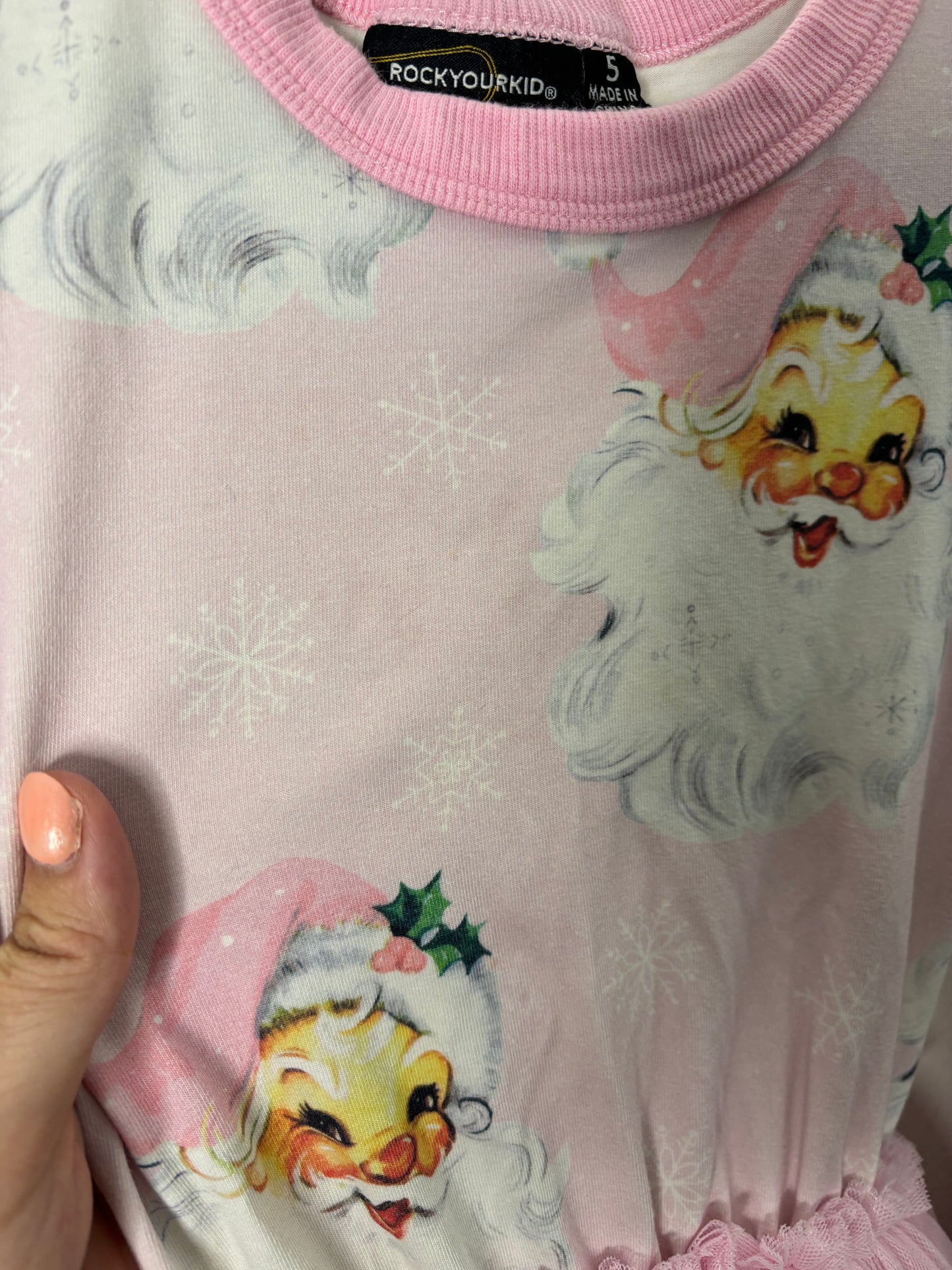 Pink long-sleeve dress with Santa Claus prints and a pink tulle skirt displayed on a hanger.
