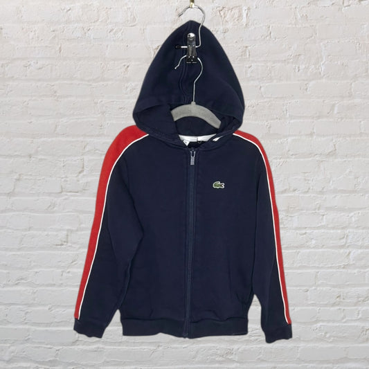 Navy blue Lacoste hoodie with full zip, featuring red and white stripes on the sleeves.