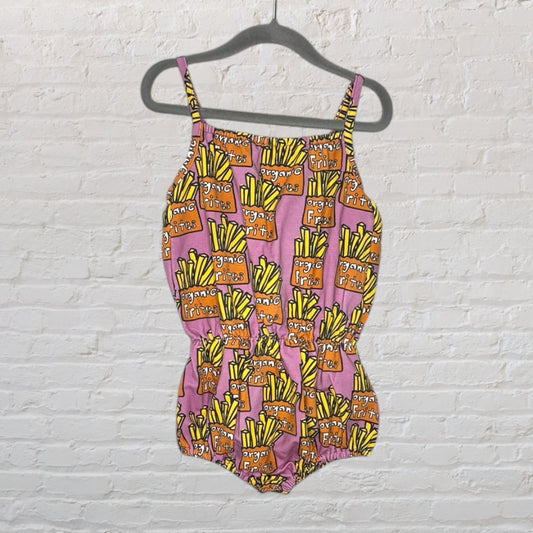 Pink romper with colorful organic fries print, featuring spaghetti straps and elastic waist, hanging on a black hanger.