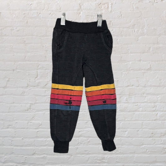 Dark wash sweatpants featuring colorful horizontal stripes around the knees, perfect for casual wear.