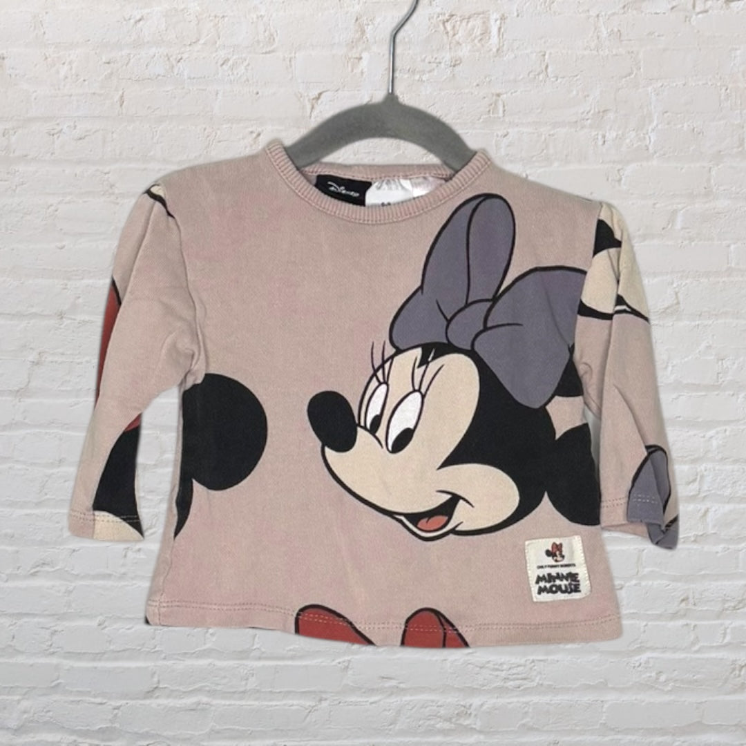 Beige long sleeve top with a large Minnie Mouse graphic and a Disney tag, hanging on a hanger.