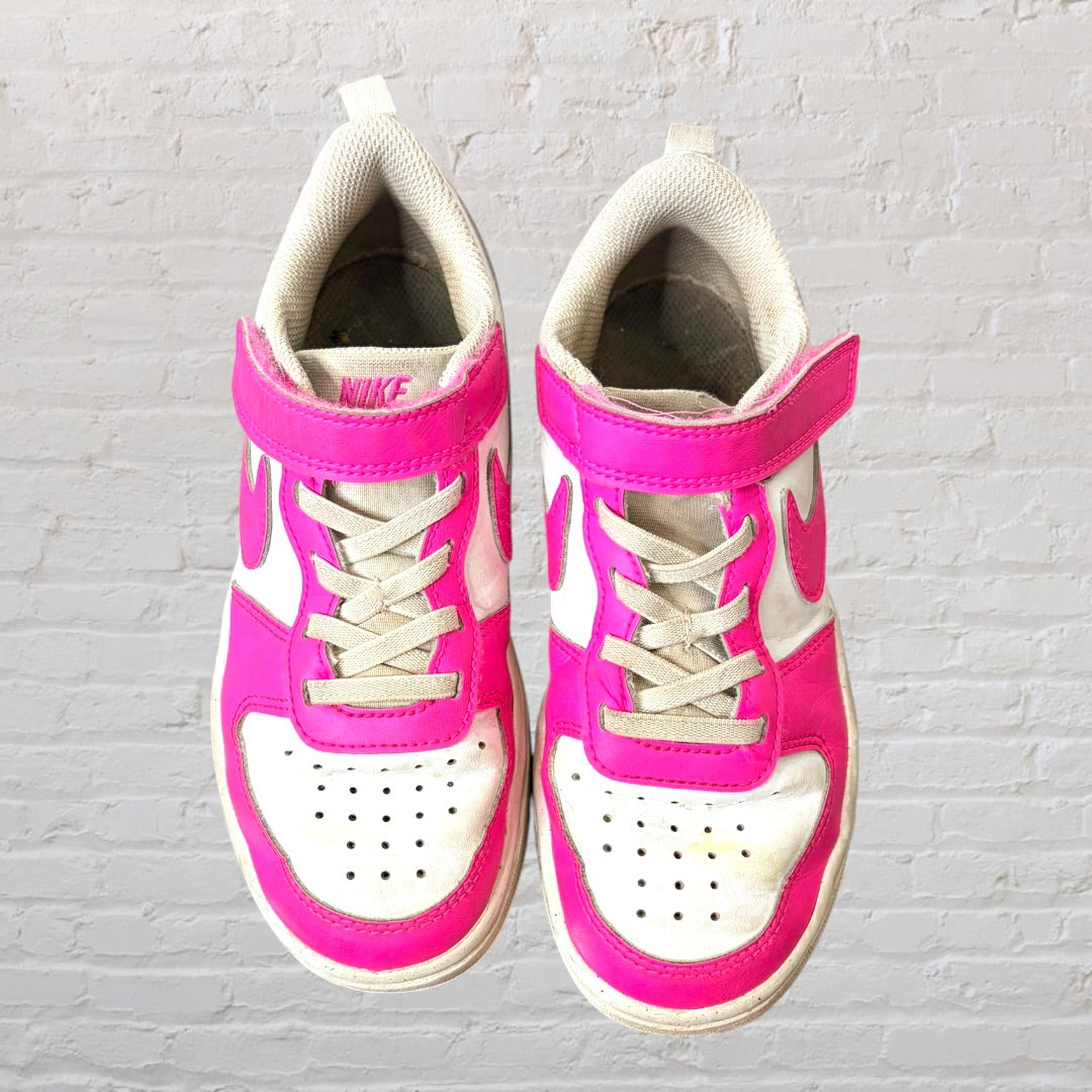 Pair of pink and white sneakers with Velcro straps and laces, showing some wear.