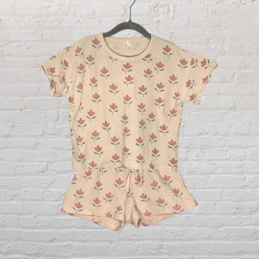 Beige waffle knit pajama set with red floral print, featuring a short-sleeve top and matching shorts, displayed on a hanger.