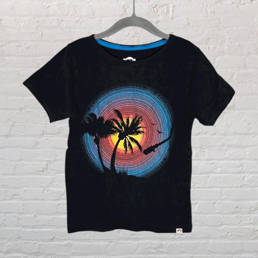 Black T-shirt featuring a vibrant sunset graphic with palm trees, displaying a beach silhouette.