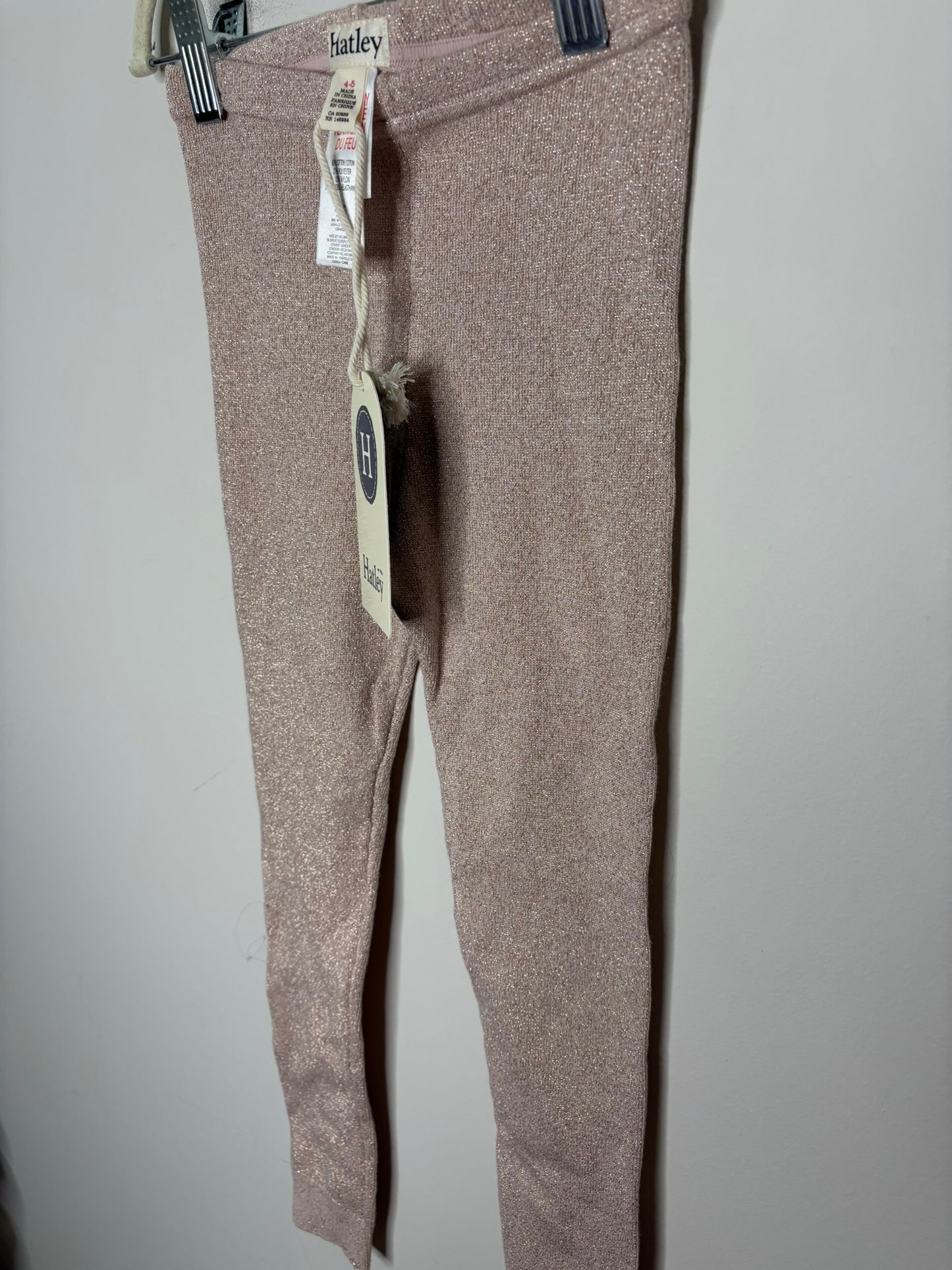 New Hatley sparkle leggings in pink with tags attached, displayed against a white brick wall.