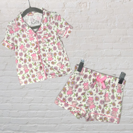 Children's pajama set with Peppa Pig and floral print in pink and white, featuring short sleeves and shorts.