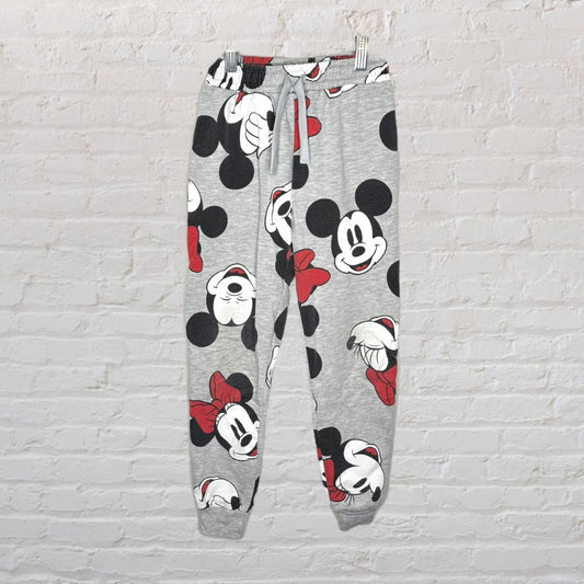 Grey jogger pajama pants featuring various expressions of Mickey and Minnie Mouse in black, white, and red accents.