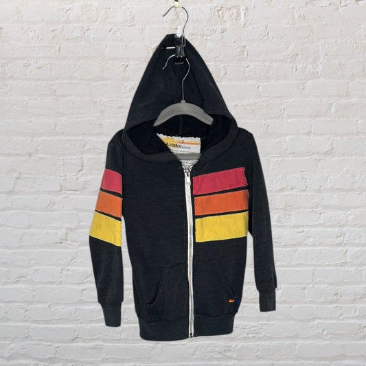 Navy zip-up hoodie with striped design in red, orange, and yellow by Aviator Nation, hanging on a wooden hanger.