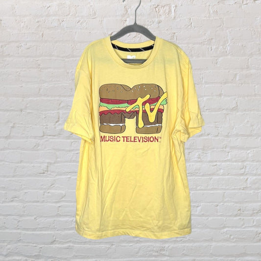 Yellow T-shirt with MTV logo designed as a burger and 'Music Television' text below, hanging on a black hanger.
