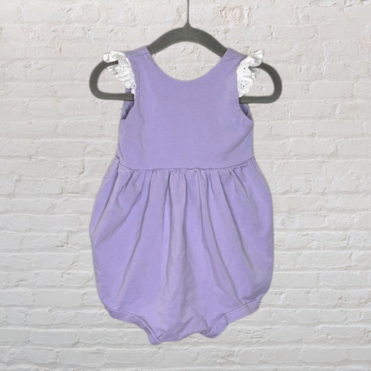 Lilac baby romper with white lace shoulder detailing, sleeveless design, shown on a hanger.
