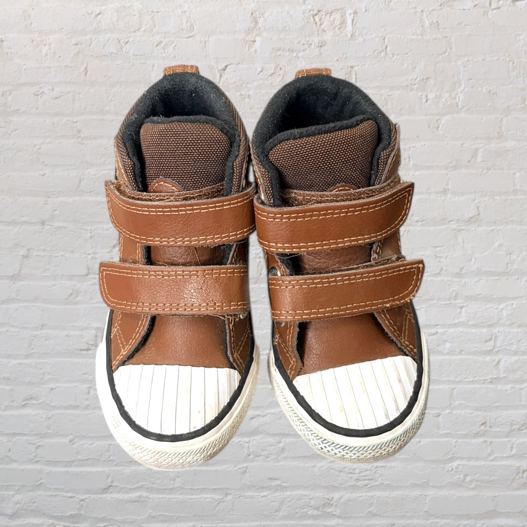 Brown high-top sneakers with Velcro straps and white rubber toe caps.